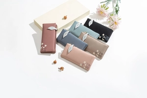 Detail showing various Morandi color wallets with leaf zippers and daisy print