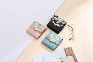 Detailed view of floral trifold wallets with gold metal clasps and PU leather texture