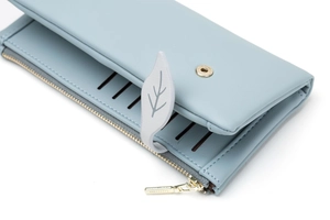 Detail of light blue PU leather wallet with leaf magnetic buckle and gold zipper compartments