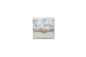 Detail of floral printed trifold wallet with gold ball clasp and metal logo trim