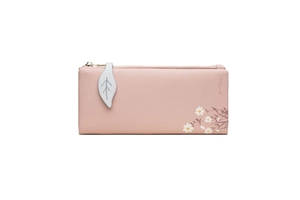 Detail of dusty rose faux leather wallet featuring leaf pendant and white flower print