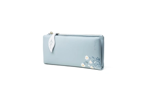 Close-up of light blue leather wallet featuring white daisy print and leaf zipper puller