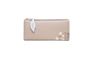 Close-up of pink PU leather wallet featuring leaf pendant and daisy floral print