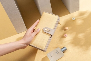 Détail du portefeuille long élégant montrant la boucle cœur dorée et le cuir texturé