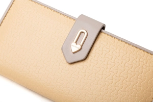 Détail du portefeuille en cuir jaune texturé avec boucle en cœur et coutures de précision