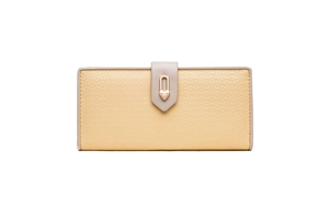 Détail du portefeuille long en cuir grainé jaune avec une boucle en cœur