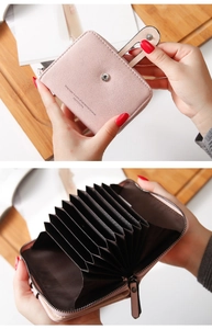 Macro detail of pink PU leather wallet showing multi-card slots and secure zipper pocket