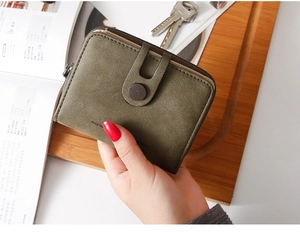 Olive green PU leather short wallet held by hand featuring a metal button detail