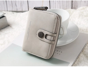Detail of light grey PU leather wallet with L-shaped zipper and snap closure compartment