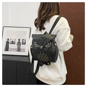 Vue arrière d'une femme portant un sac à dos hibou en cuir PU noir avec broderie dorée