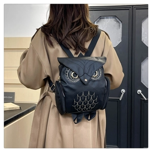 Détail du sac à dos chouette en similicuir avec broderie dorée porté par un mannequin