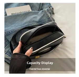 Detail der zwei Reißverschlussfächer und des Innenraums der schwarzen Umhängetasche