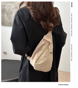 Close-up of beige nylon chest bag with minimalist texture and blue woven tag detail