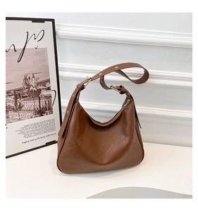 Detail of vintage brown hobo bag showing pleated texture and adjustable gold hardware