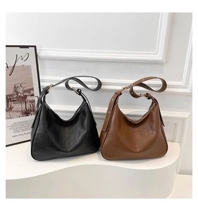 Two crescent-shaped hobo bags in black and brown soft leather finish with gold hardware