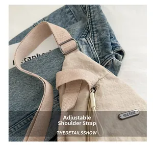 Detail of adjustable strap with dark grey metal buckle on beige nylon crossbody chest bag