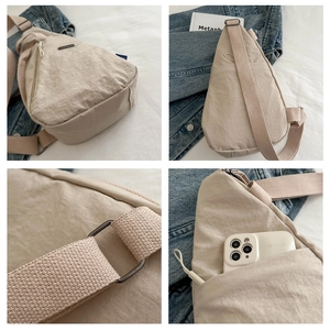 Detail view of beige nylon crossbody bag featuring adjustable strap and multi-pocket design