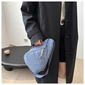 Detail der blauen Nylon-Halbmondtasche am Modell mit verstellbarem Gurt und Fronttasche