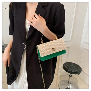 Détail du sac bandoulière en cuir vert et paille avec poignée dorée et fermoir métal