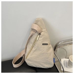 Detailansicht der leichten beigen dreieckigen Crossbody-Brusttasche mit verstellbarem Gurt