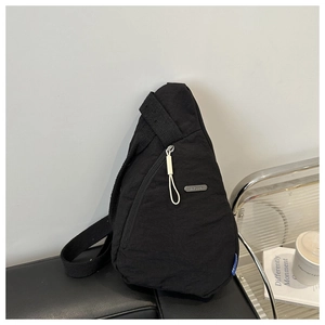 Detailaufnahme der schwarzen Brusttasche mit JINGPIN Metallschild und blauem Label
