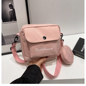 Detail view of pink canvas crossbody bag with Dachshund print and matching round coin purse