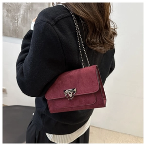 Sac bandoulière en daim bordeaux avec fermoir bouclier argenté et bandoulière chaîne