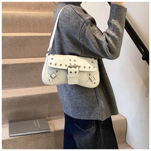 Detail of white Y2K punk shoulder bag with silver metal rivets and leather buckle straps