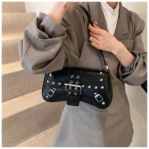 Close-up of black punk shoulder bag featuring silver rivets and metallic buckle details