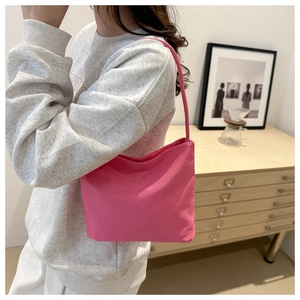 Close-up of pink shoulder bag with pretty and libety embossed text on nylon fabric