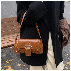 Detail of retro punk shoulder bag featuring silver metal rivets and large buckle decor