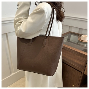Detail of dark brown tote bag featuring premium lychee texture and fine shoulder straps