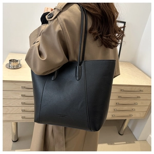 Detailed view of black litchi pattern leather tote bag with elegant shoulder straps