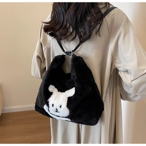 Detail of black plush tote bag featuring a 3D white rabbit motif and metallic chain strap