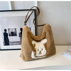Detail of plush brown faux fur hobo bag featuring a cute white rabbit patch and leather strap