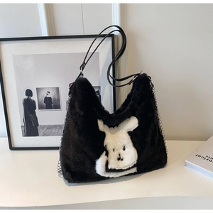 Detail of soft black faux rabbit fur tote with white bunny pattern and silver chain strap