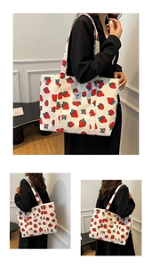 Detail of white nylon tote bag with strawberry print and grey woven label patch