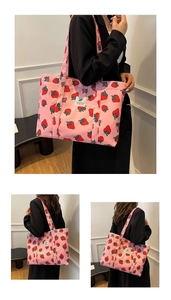 Detail of pink canvas tote bag with strawberry print and white woven label logo