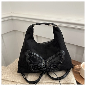 Détail du sac en daim noir avec patchwork d'ailes papillon en cuir et design à lacets