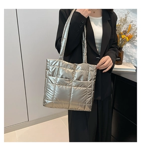 Detail of silver quilted puffer tote bag showing metallic texture and stitching
