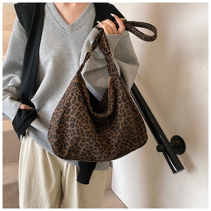 Macro view of leopard print canvas fabric with metal zipper and adjustable strap detail