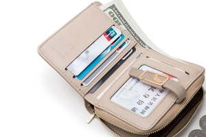 Interior view of beige bi-fold wallet featuring card slots and leaf metal clasp detail