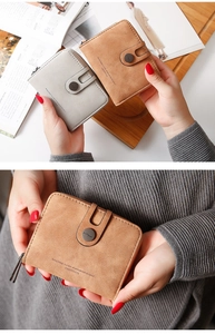 Close-up of minimalist PU leather short wallets featuring zip pockets and metal buckles
