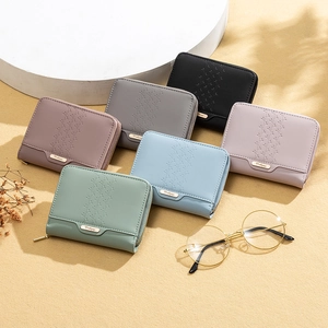 Flat lay of short PU leather wallets in various pastel colors with leaf embossing