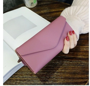 Close-up of elegant pink leather envelope wallet with gold zipper and stitching detail