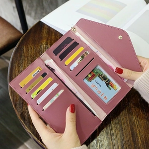 Long mauve PU leather wallet with multiple card slots and envelope flap on wooden desk