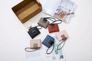 Flat lay view of short PU leather wallets in various colors with geometric embossed patterns
