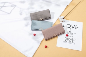 Detailed view of long PU leather wallets with V-shaped quilting and gold flower buckle