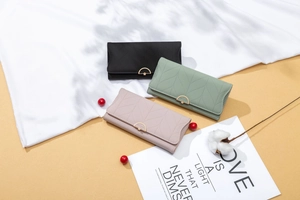Detailed view of long PU leather wallets in green, pink and black with leaf stitching