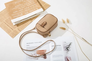 Vue à plat d'un mini sac bandoulière kaki avec boucle flèche et accessoires vintage